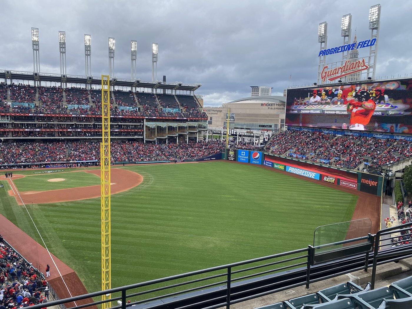 Progressive Field in Cleveland seen from the upper deck down the left field line, with the Guardians scoreboard above center field